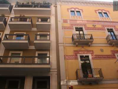 Foto 9. Fiancheggiamo piazza Umberto e all�incrocio con via Beatillo notiamo un elegantissimo e ristrutturato palazzo dagli accesi colori giallo e rosa, contiguo a uno smorto stabile verdastro con geometrici balconi neri 
